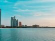Abu Dhabi city skyline across a body of water during the day