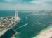 Aerial view of the Dubai waterfront with a Ferris wheel, beach and towers