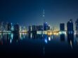 Dubai skyline with Burj Khalifa reflected in the water at night