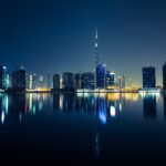 Dubai skyline with Burj Khalifa reflected in the water at night