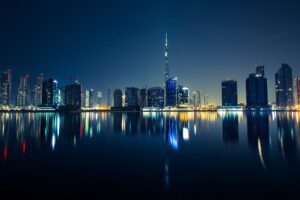 Dubai skyline with Burj Khalifa reflected in the water at night