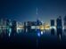 Dubai skyline with Burj Khalifa reflected in the water at night