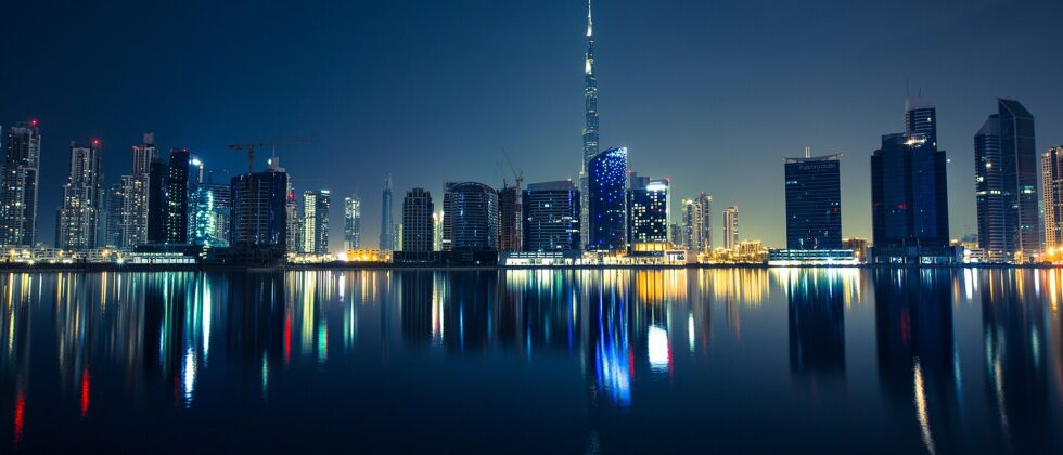 Dubai skyline with Burj Khalifa reflected in the water at night