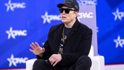 Elon Musk speaking on stage as neocloud stocks fall