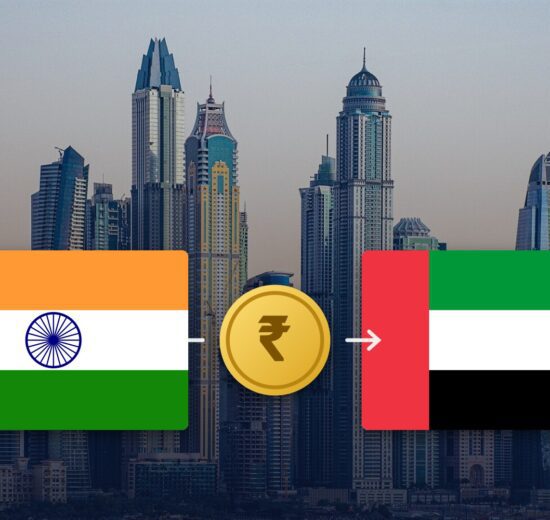 Indian and UAE flags with a rupee coin over the Dubai Marina skyline
