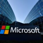 Microsoft sign in front of glass office buildings
